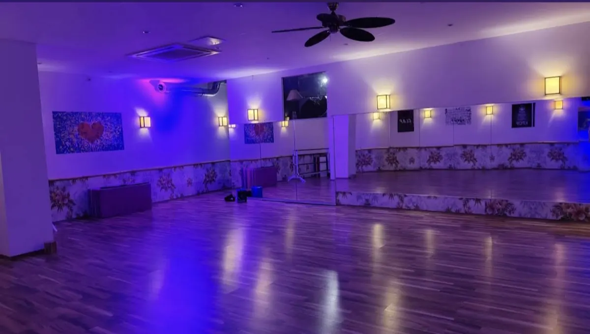 Eventlocation Köln: Saal mit lila LED-Licht, Holzboden und Spiegelwand in Ehrenfeld