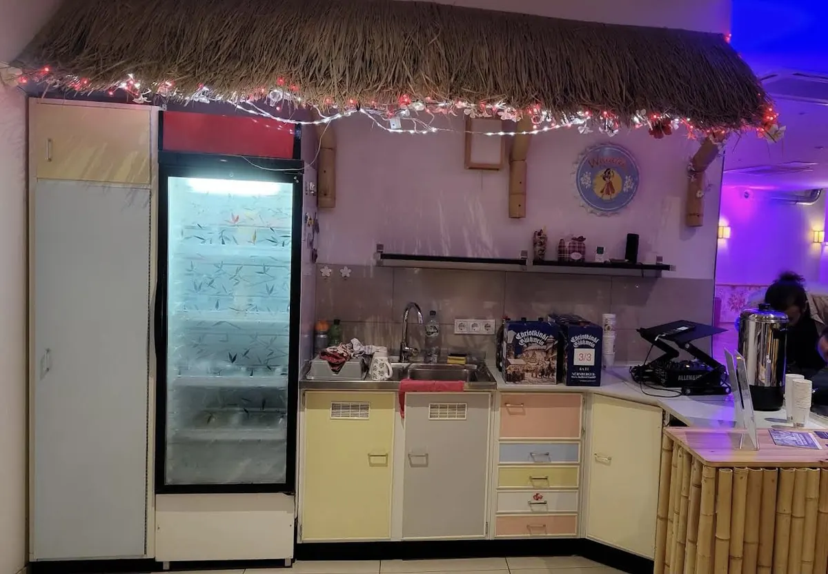 Theke mit Strohdach, Getränkekühlschrank und DJ-Pult in der Eventlocation Köln